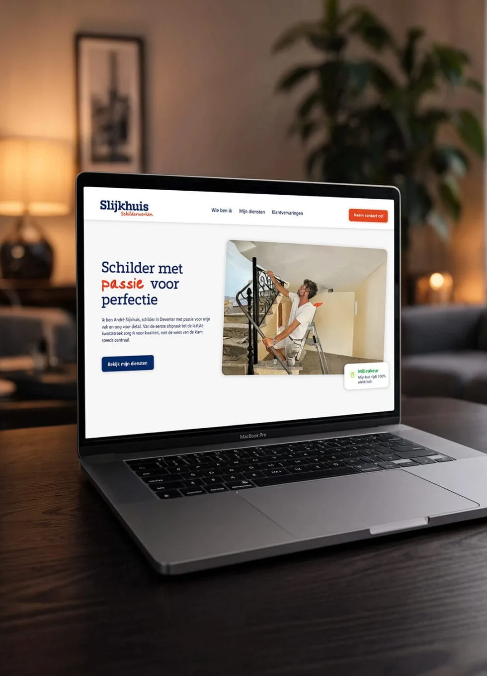 De website van Slijkhuis Schilderwerken op een laptop op een houten bureau.